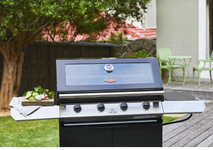 Vista de la barbacoa de gas con tapa cerrada y ventana panorámica, integrada en una terraza como parte de una cocina exterior modular