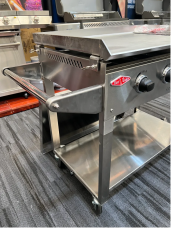 Vista lateral de la barbacoa de gas BeefEater Clubman Inox con carro plegable de acero inoxidable, diseñada para una máxima movilidad y durabilidad en eventos exteriores