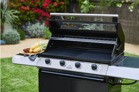 Vista angular de la zona de cocción de la barbacoa encastrable con rejillas esmaltadas y estante de calentamiento